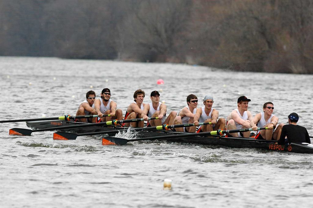 A group of people rowing a boat in the water