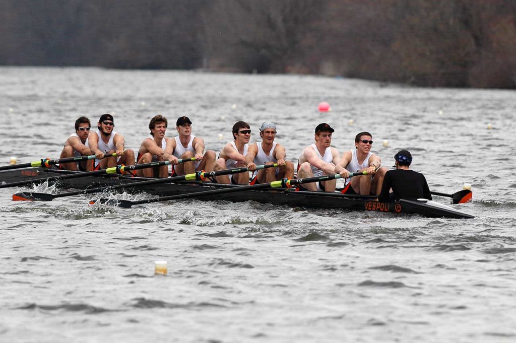 A group of people rowing a boat in the water