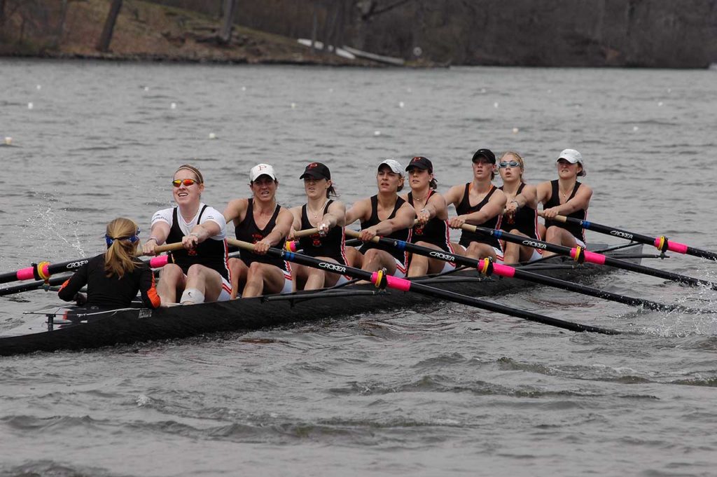 A group of people rowing a boat in the water