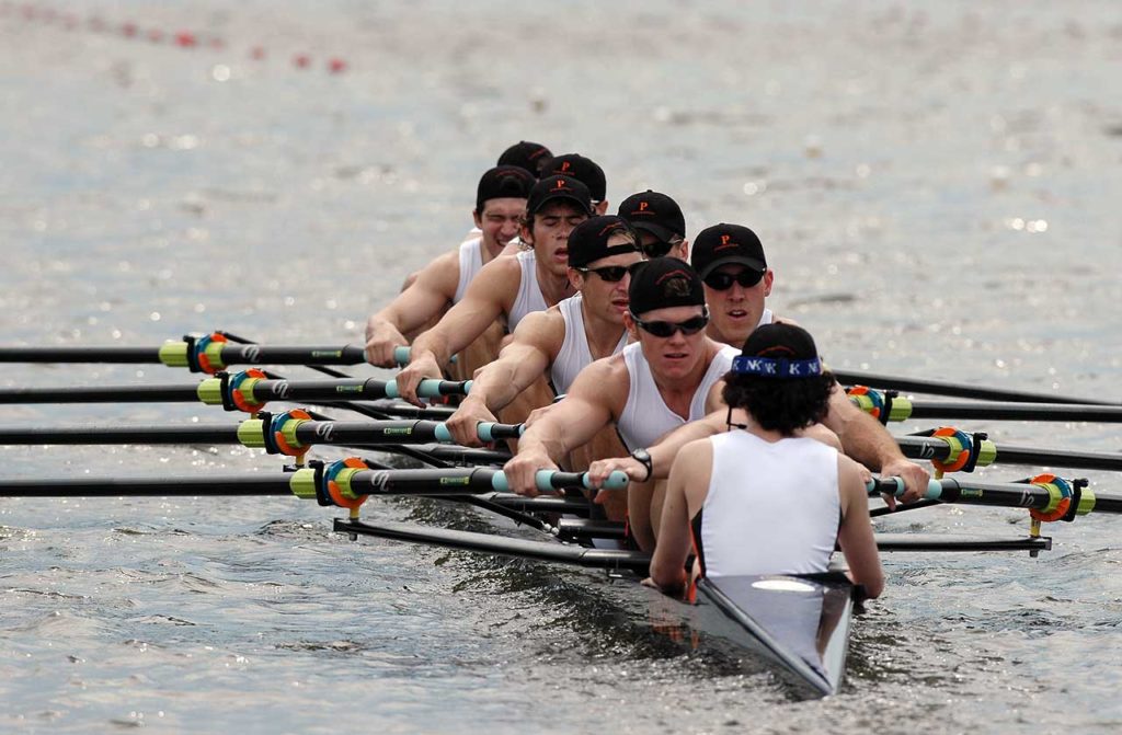 A group of people rowing a boat in the water