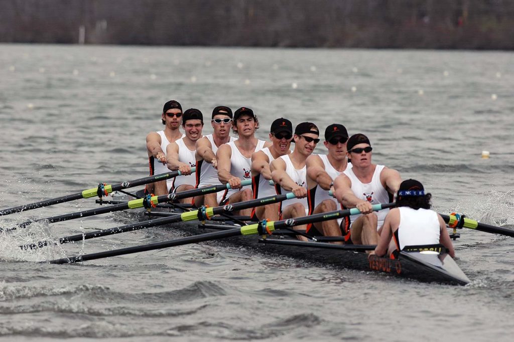 A group of people rowing a boat in the water