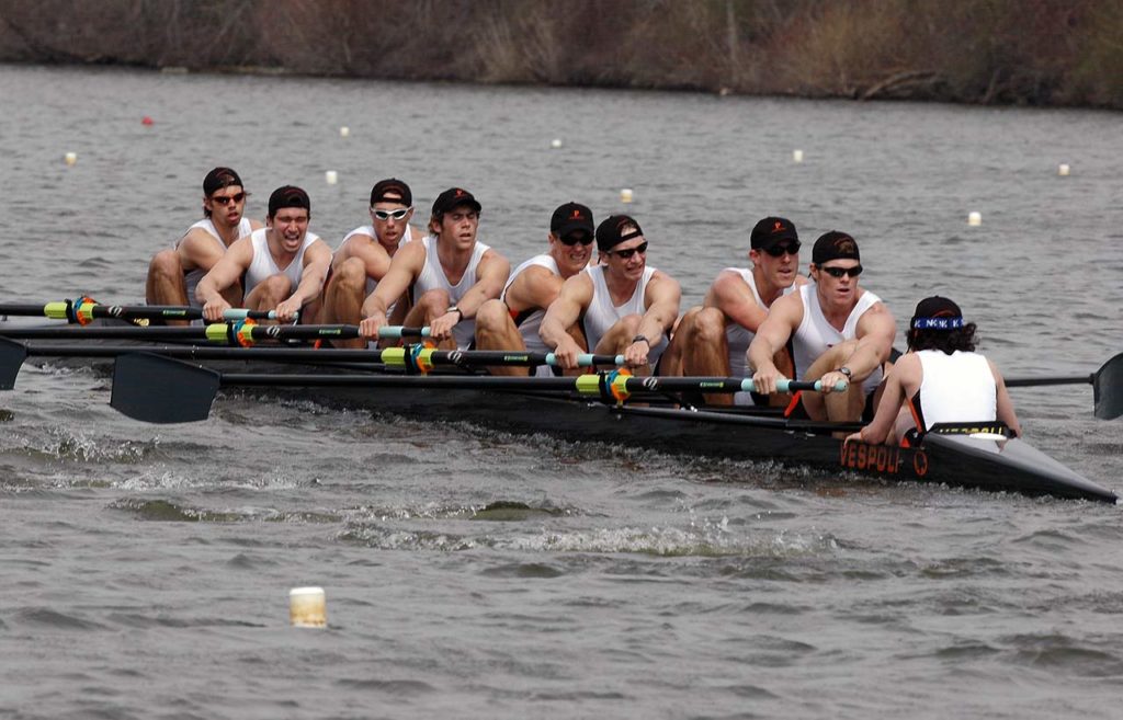 A group of people rowing a boat in the water