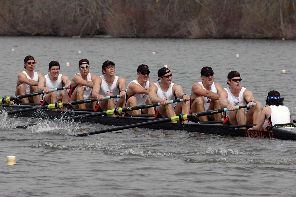 A group of people rowing a boat in the water