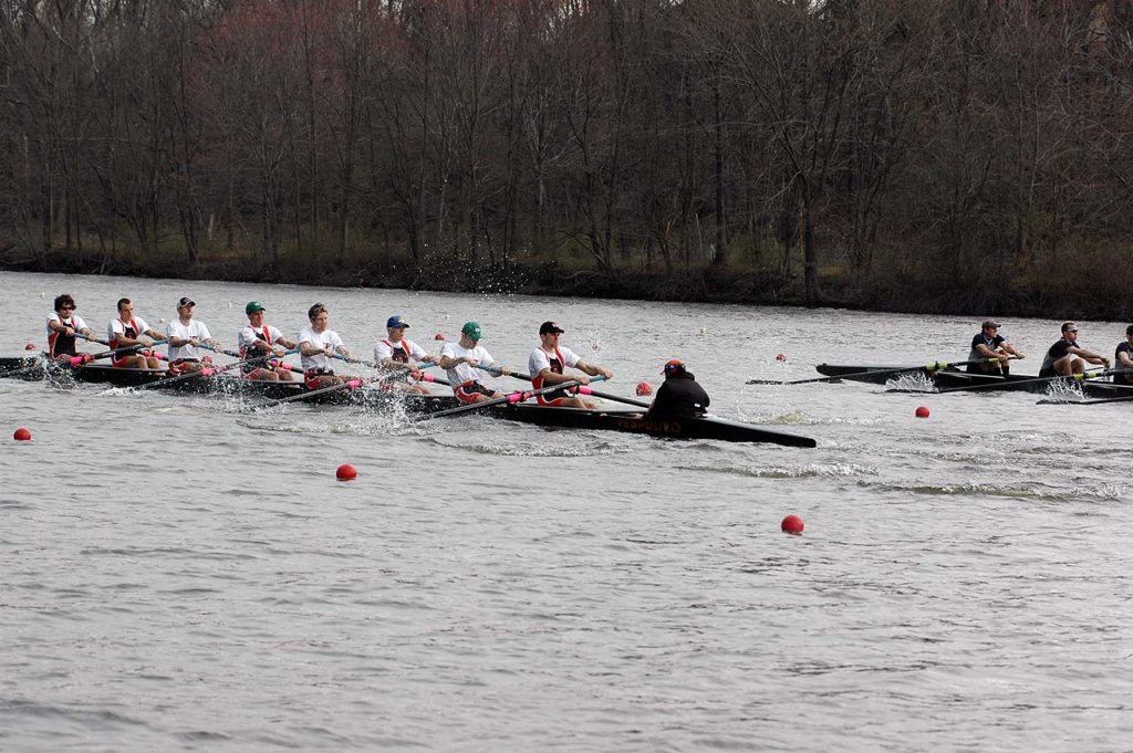 A group of people rowing a boat in a body of water