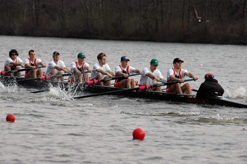 A group of people rowing a boat in the water