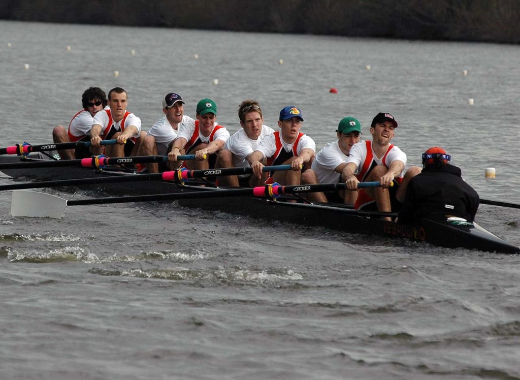 A group of people rowing a boat in the water