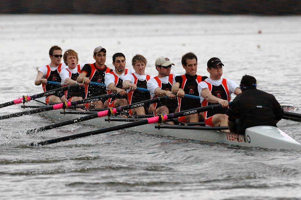 A group of people rowing a boat in the water