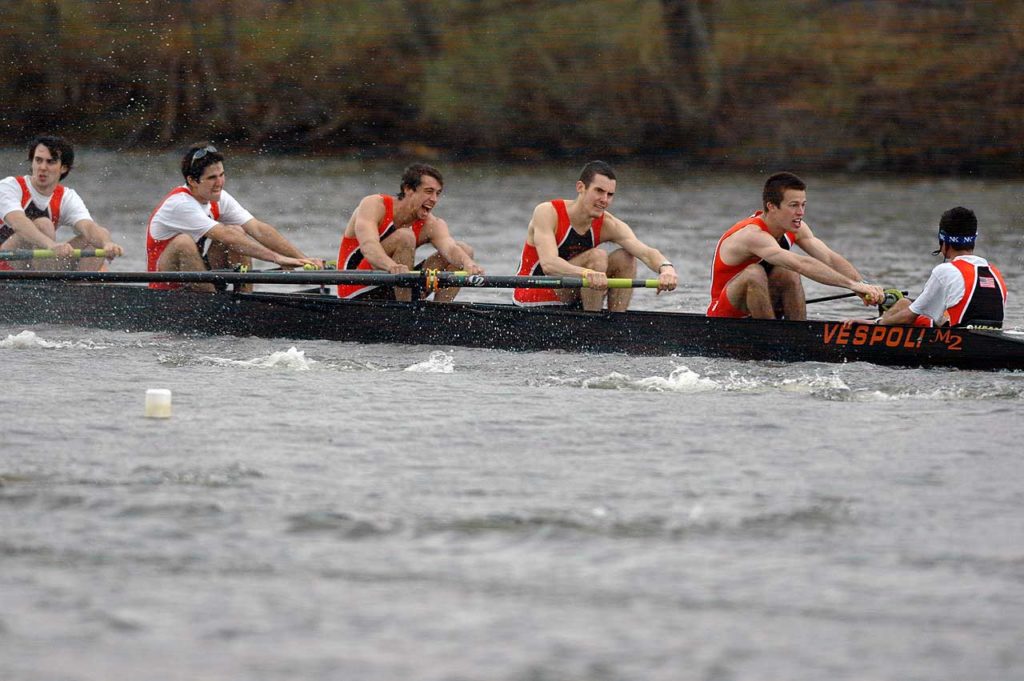 A group of people rowing a boat in the water