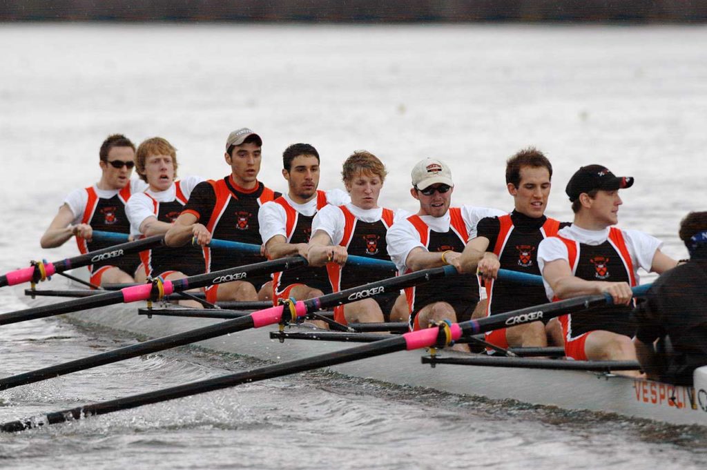 A group of people rowing a boat in the water