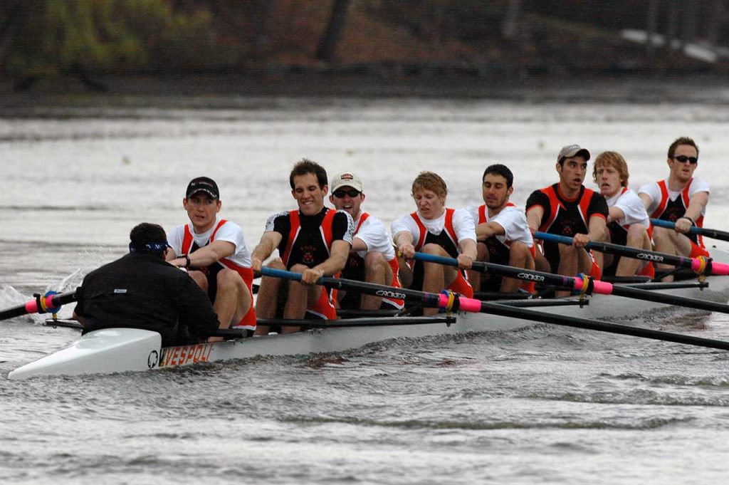 A group of people rowing a boat in the water