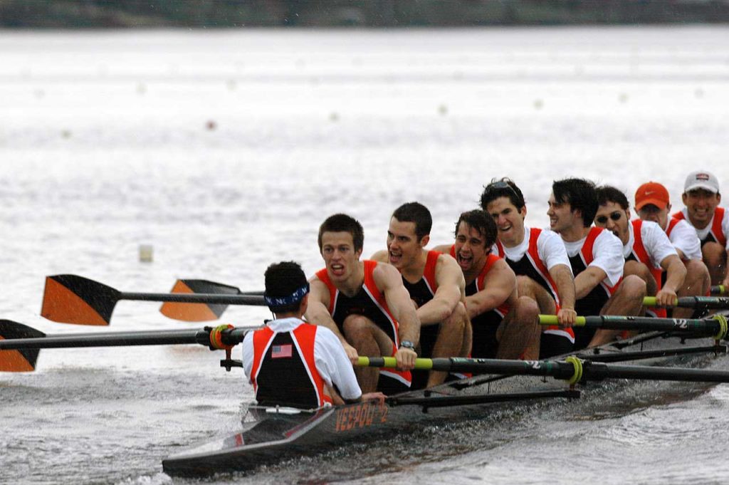 A group of people rowing a boat in a body of water