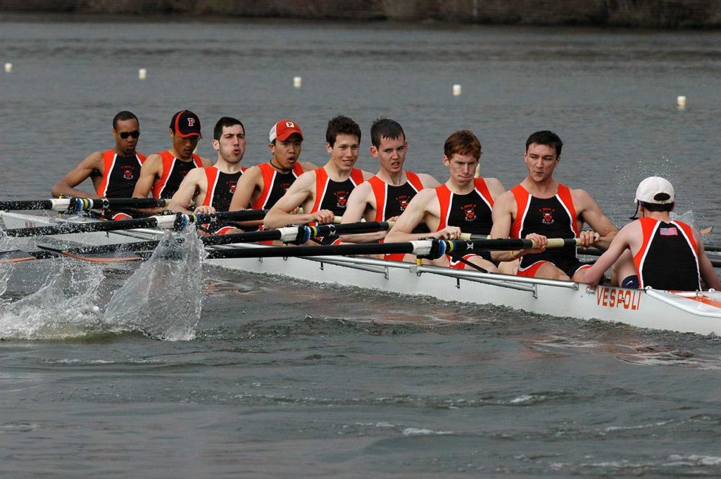 A group of people rowing a boat in the water