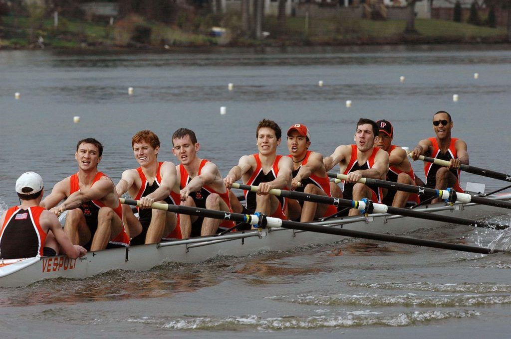 A group of people rowing a boat in the water