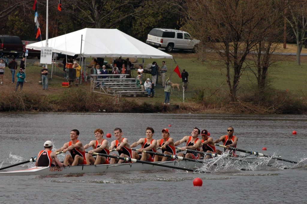 A group of people rowing a boat in the water