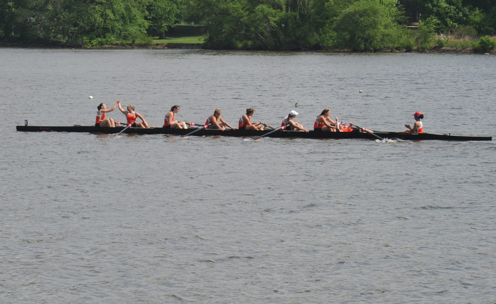 A group of people rowing a boat in a body of water