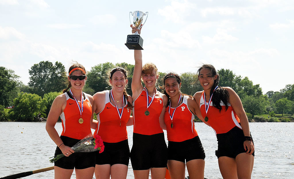 A group of people standing next to a body of water