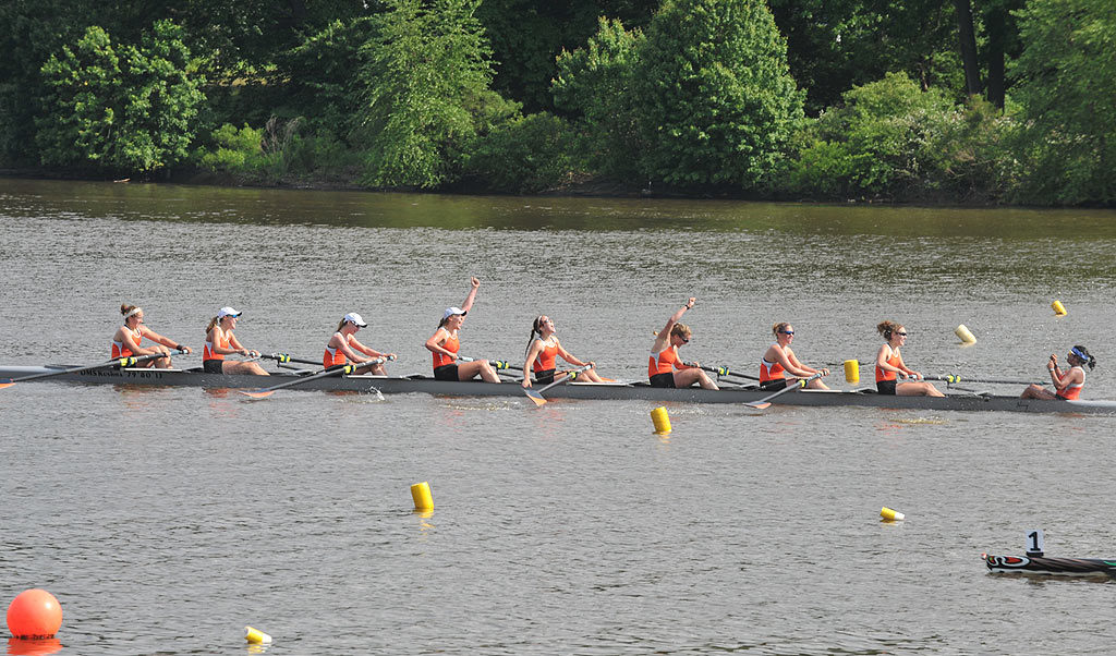 A group of people rowing a boat in the water