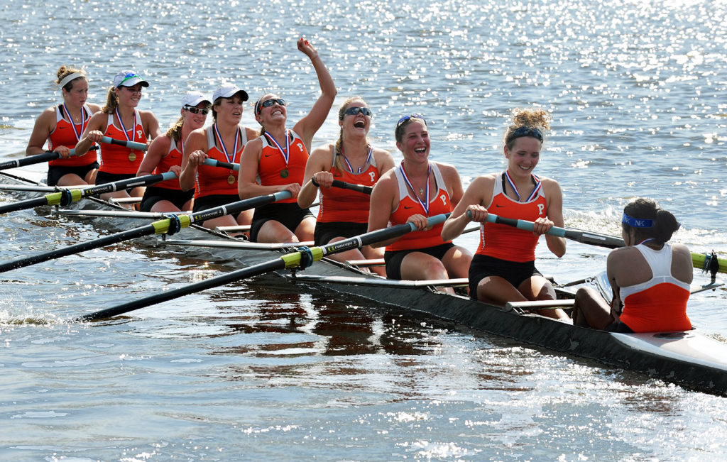 A group of people rowing a boat in the water