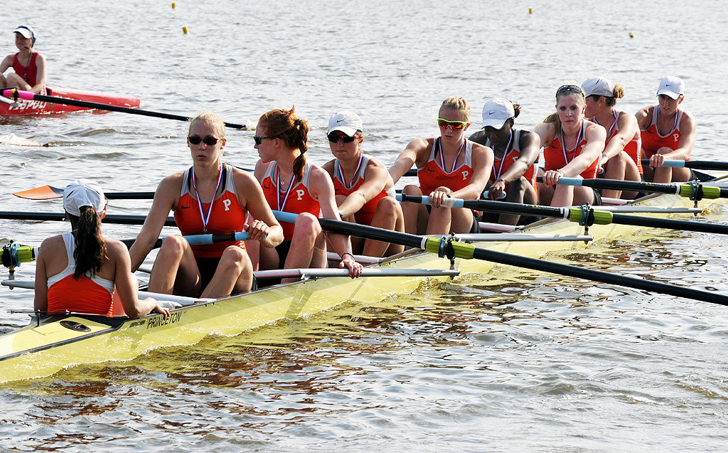 A group of people rowing a boat in the water