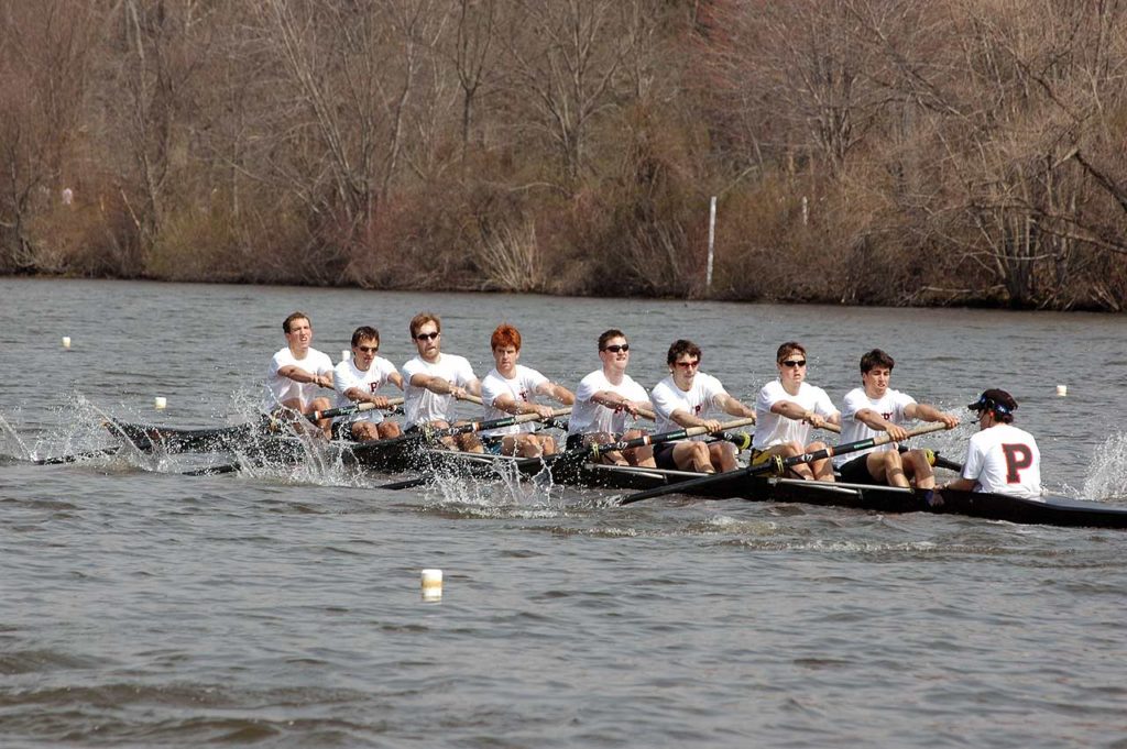 A group of people rowing a boat in a body of water