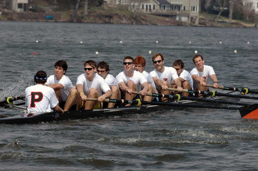 A group of people rowing a boat in the water