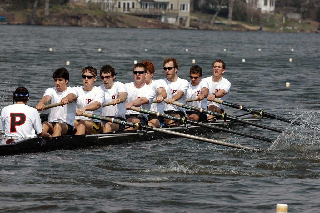 A group of people rowing a boat in the water