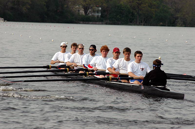 A group of people rowing a boat in a body of water