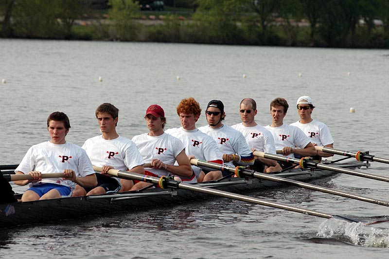 A group of people rowing a boat in a body of water