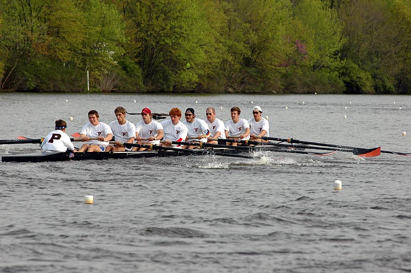 A group of people rowing a boat in a body of water