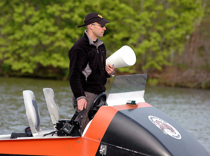 A person riding on the back of a boat in the water