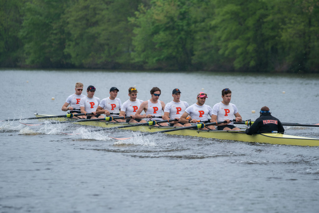 A group of people rowing a boat in a body of water