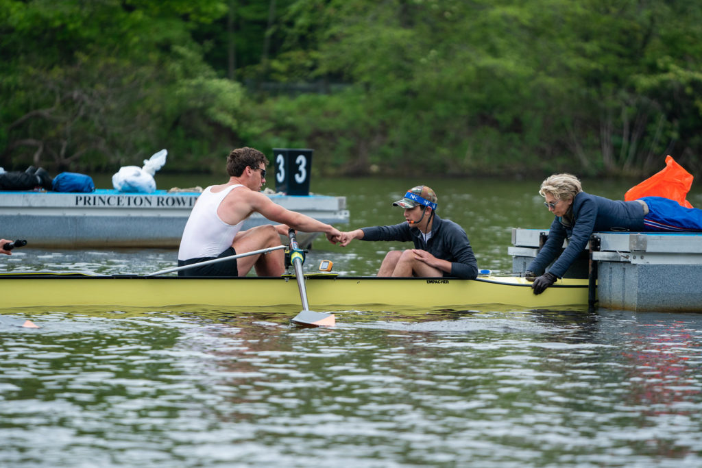 A group of people rowing a boat in the water