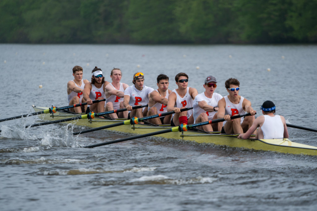 A group of people rowing a boat in a body of water