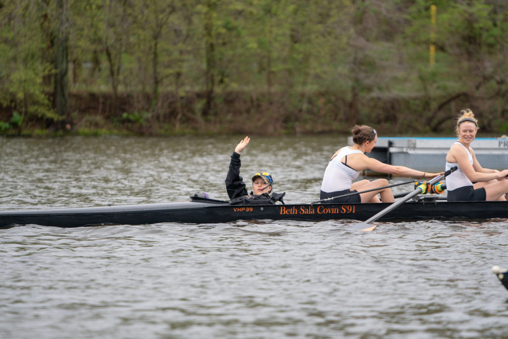 A group of people rowing a boat in a body of water