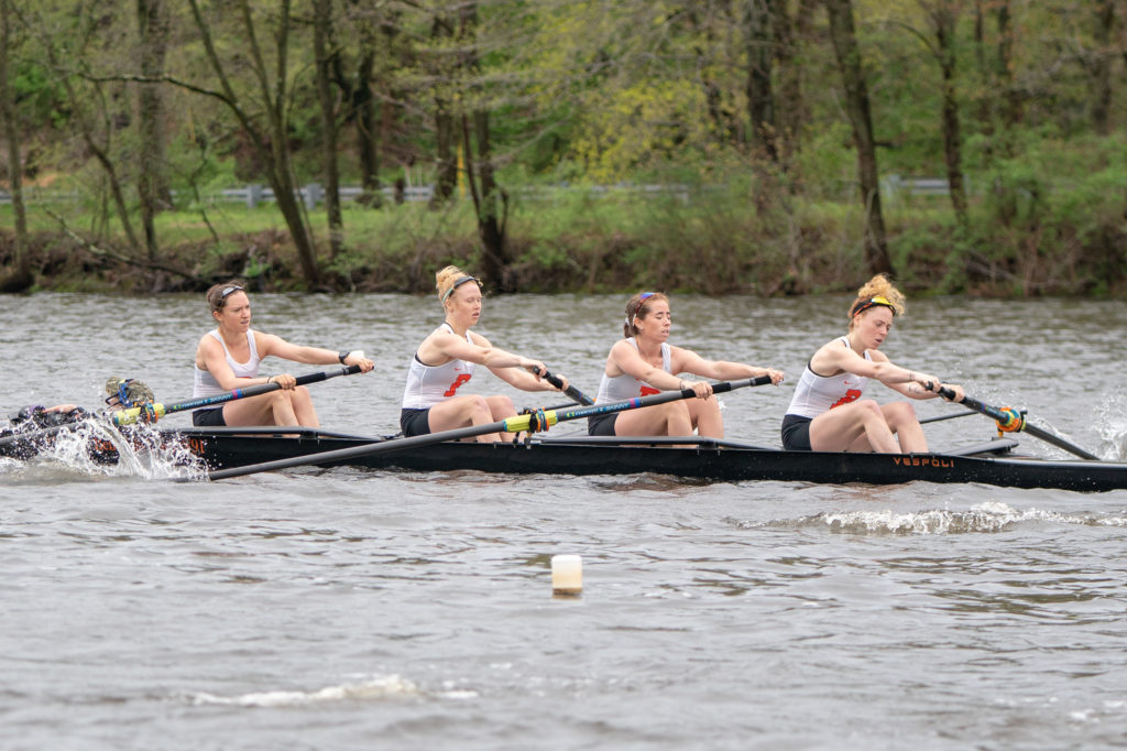 A group of people rowing a boat in the water