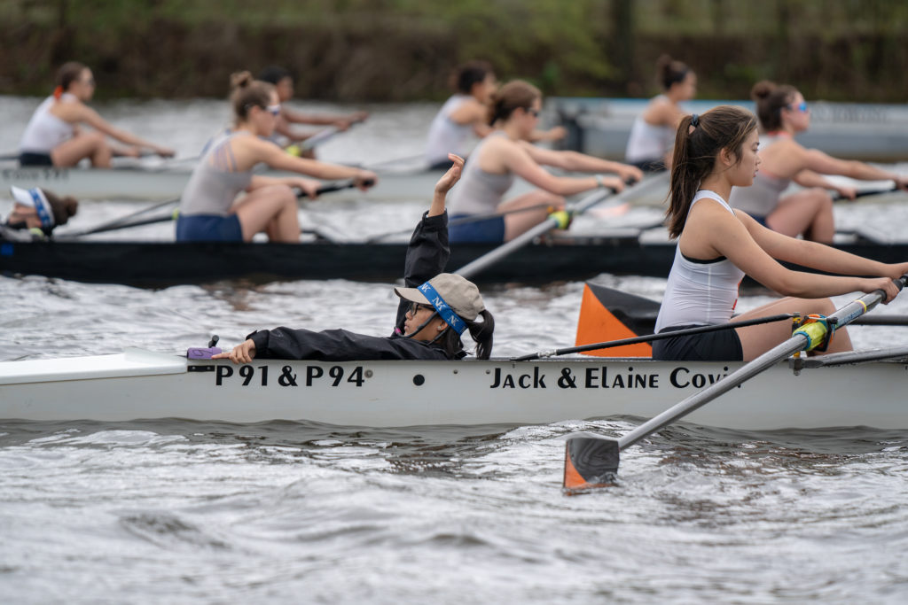 A group of people rowing a boat in the water