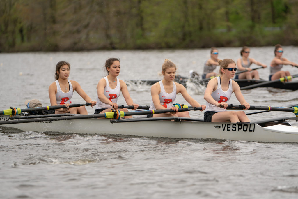 A group of people rowing a boat in the water