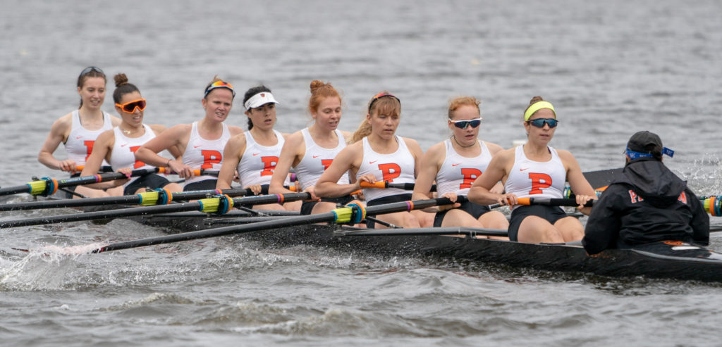 A group of people rowing a boat in the water