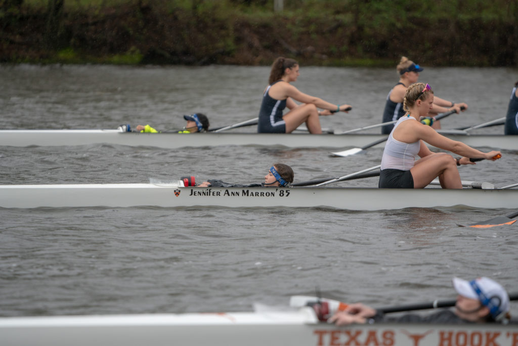 A group of people rowing a boat in the water