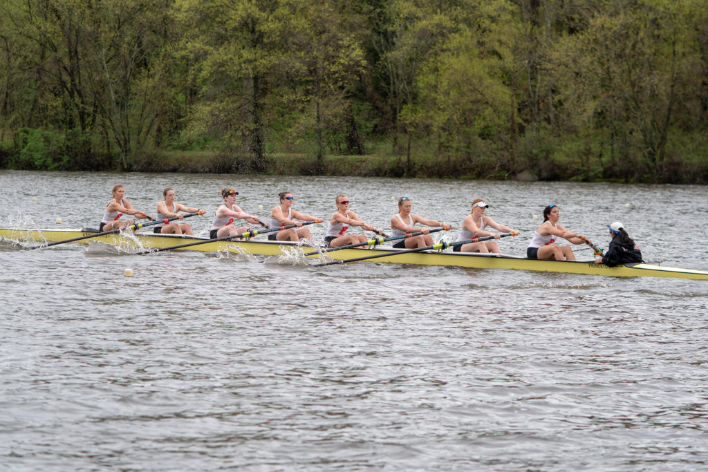 A group of people rowing a boat in a body of water