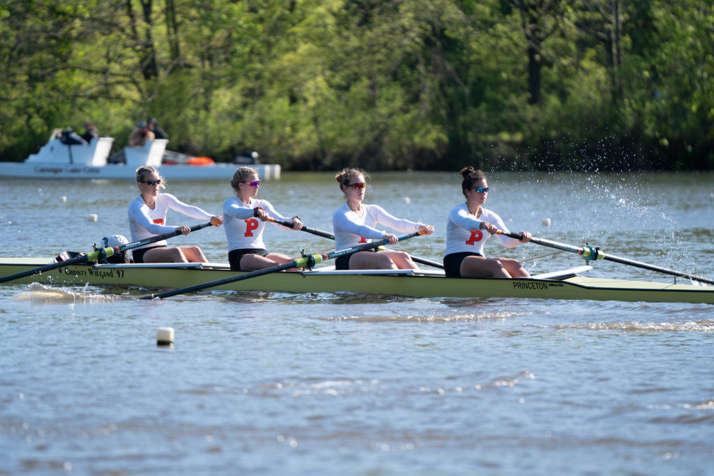 A group of people rowing a boat in a body of water