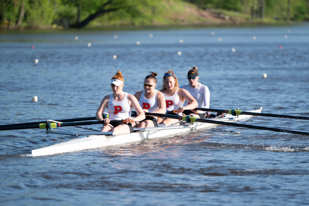 A group of people rowing a boat in a body of water