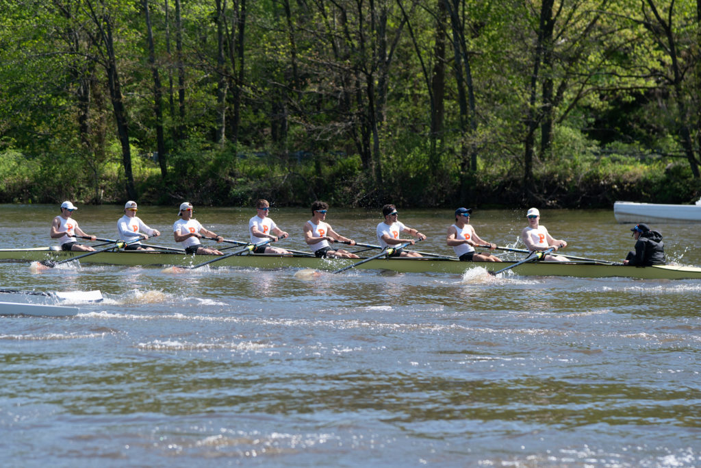 A group of people rowing a boat in the water