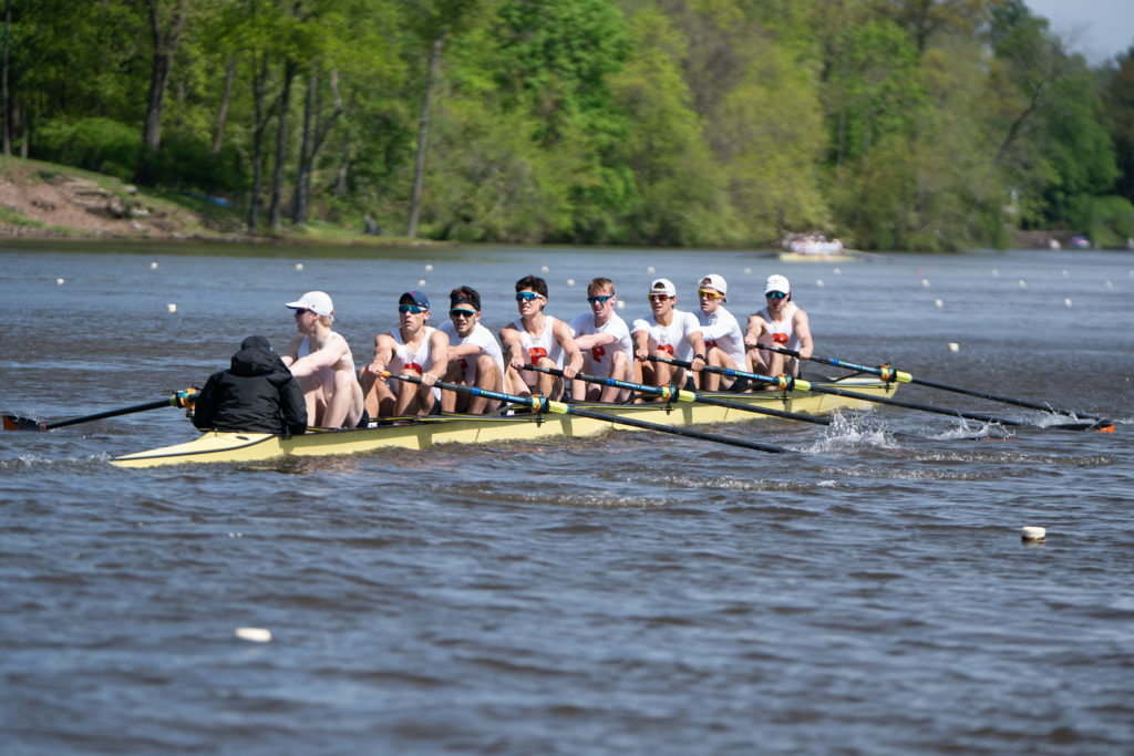 A group of people rowing a boat in a body of water