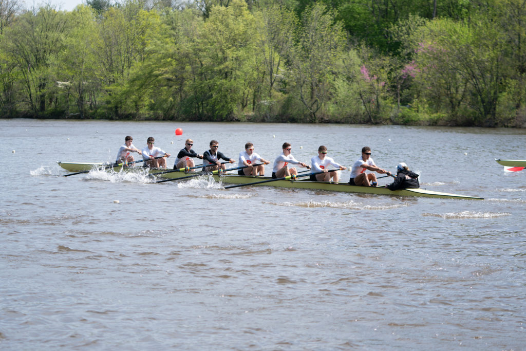 A group of people rowing a boat in a body of water