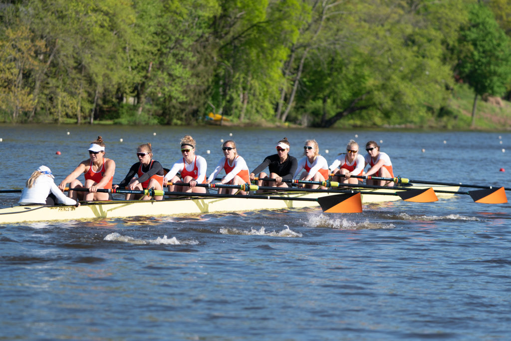 A group of people rowing a boat in a body of water