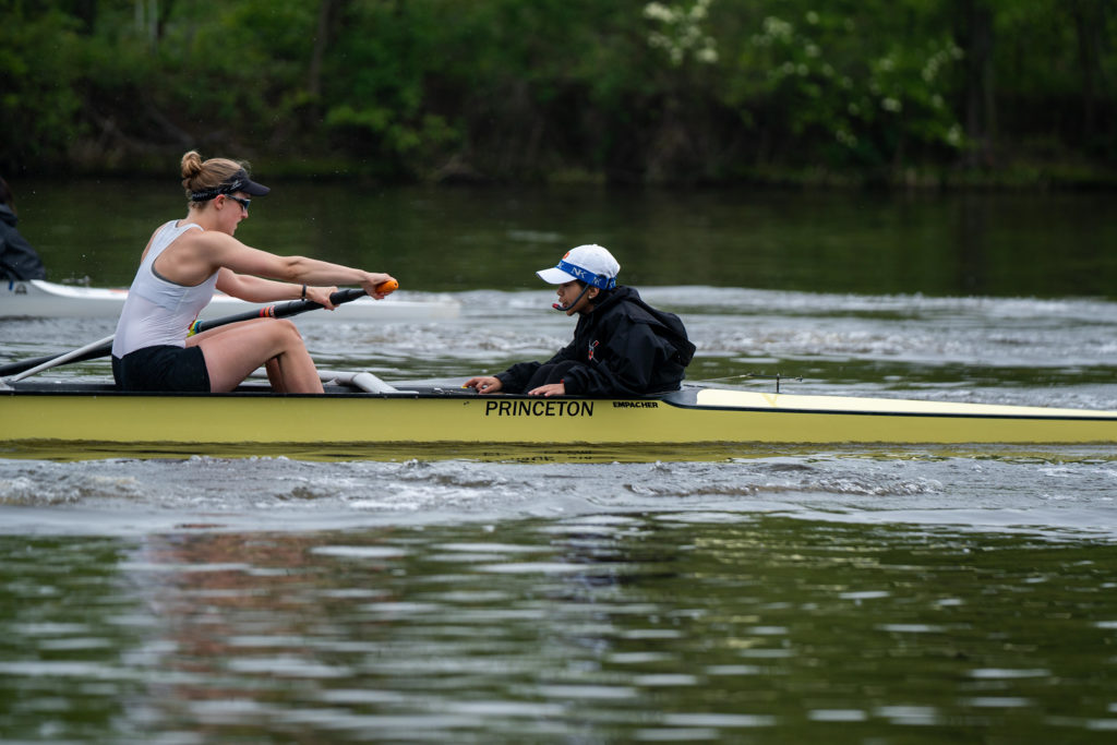 A group of people rowing a boat in a body of water