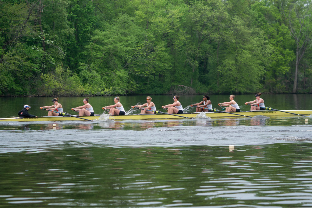 A group of people rowing a boat in a body of water