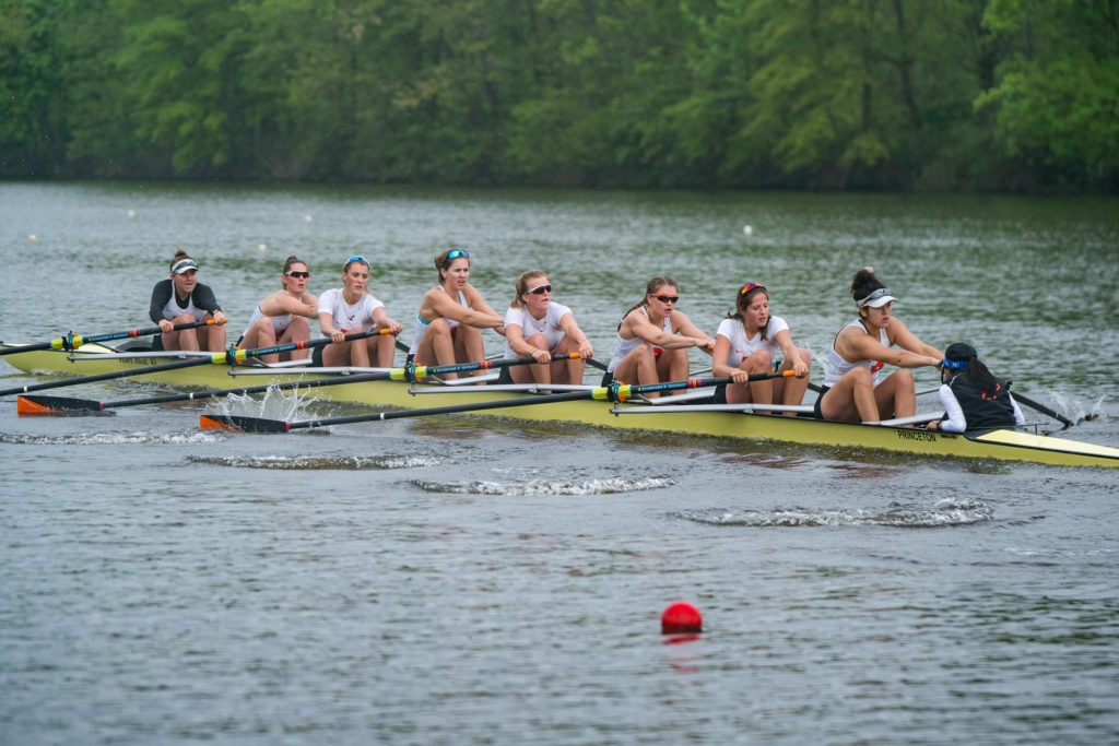 A group of people rowing a boat in a body of water