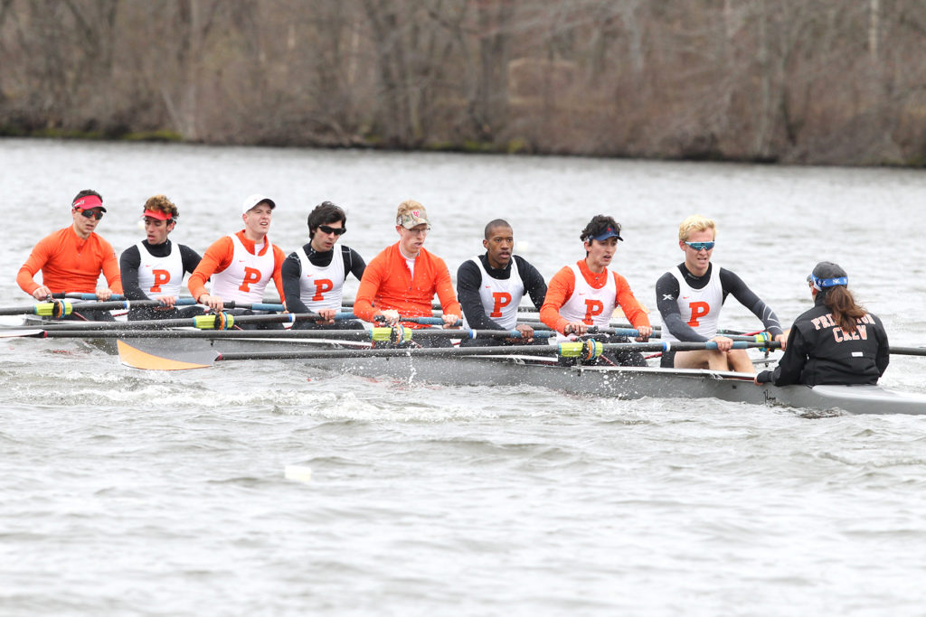 A group of people rowing a boat in the water